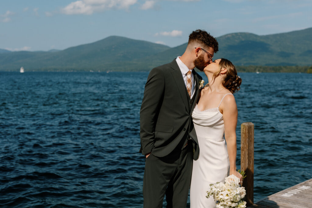 Lake George NY wedding photographer. Couple kissing on lake.