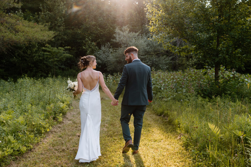 couple walking in the woods in the Adirondacks. Adirondack wedding photographer